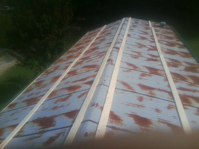 Rusted metal roof panels with new wood purlins before replacement — Storm Damage Roof Repair in Olanta by Roofing Brothers